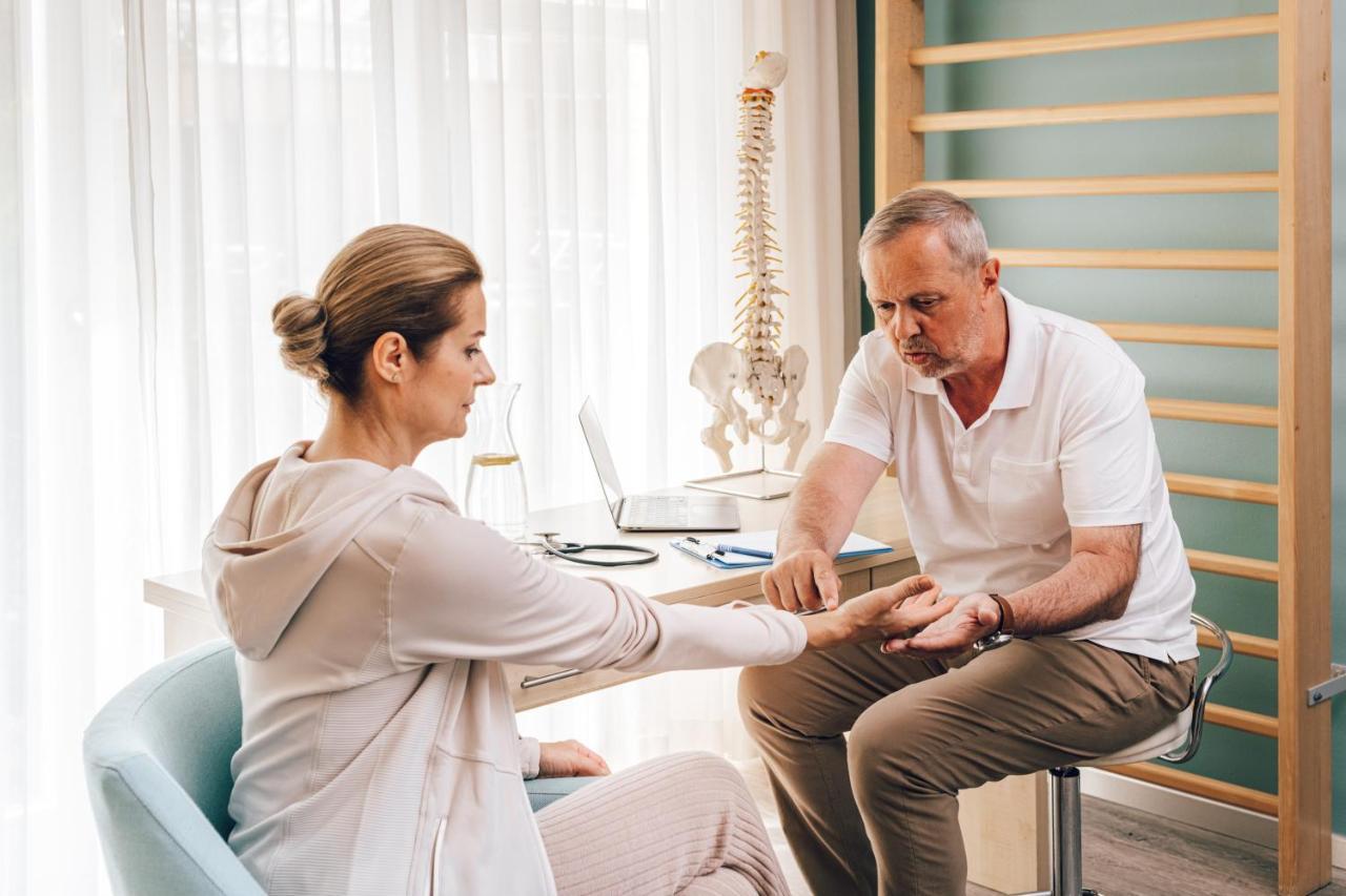 Falkensteiner Spa Resort Mariánské Lázně Exterior foto A chiropractor examines a patient's wrist